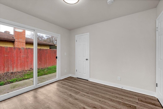 unfurnished room featuring wood finished floors and baseboards