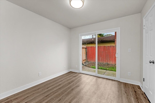 empty room with baseboards and wood finished floors