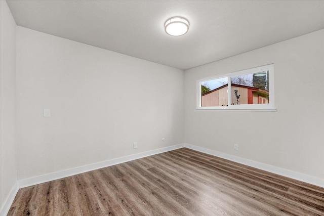 empty room featuring baseboards and wood finished floors