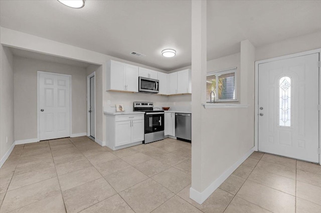 kitchen featuring appliances with stainless steel finishes, light countertops, white cabinets, and visible vents