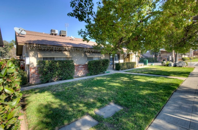 view of front of house with a front yard and central air condition unit