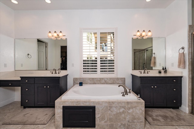 bathroom with vanity and shower with separate bathtub