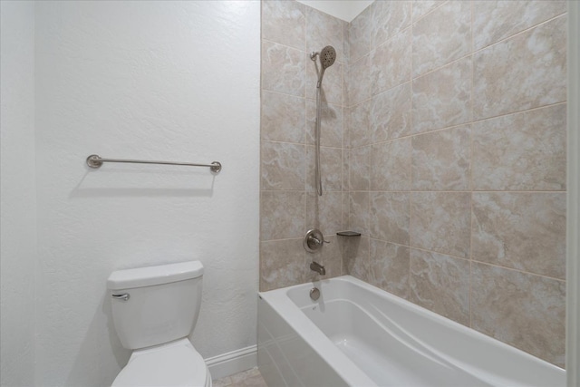 bathroom featuring tiled shower / bath and toilet