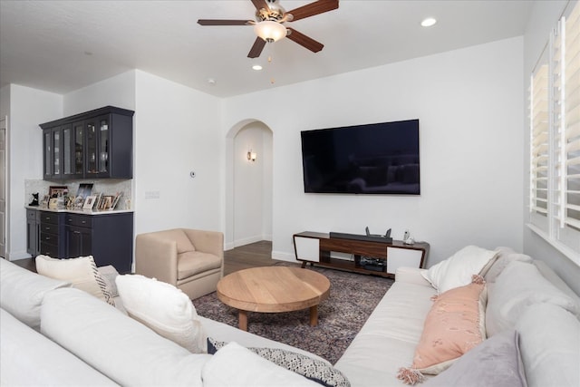 living room with dark wood-type flooring and ceiling fan