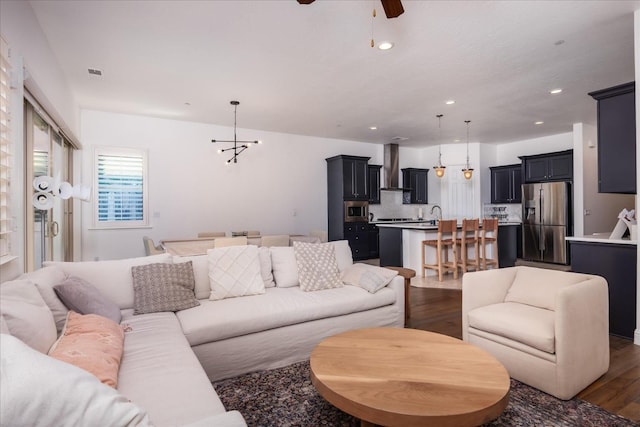 living room with dark wood-type flooring and ceiling fan