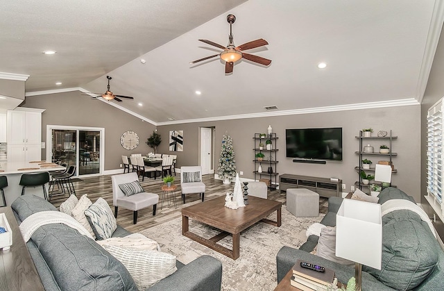 living room with lofted ceiling, light hardwood / wood-style flooring, ornamental molding, and ceiling fan