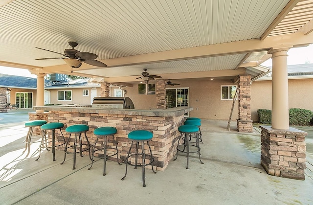 view of patio with grilling area, an outdoor bar, and ceiling fan