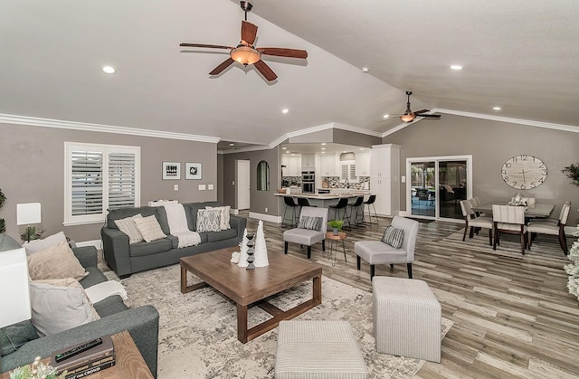 living room featuring crown molding, lofted ceiling, ceiling fan, and light hardwood / wood-style flooring