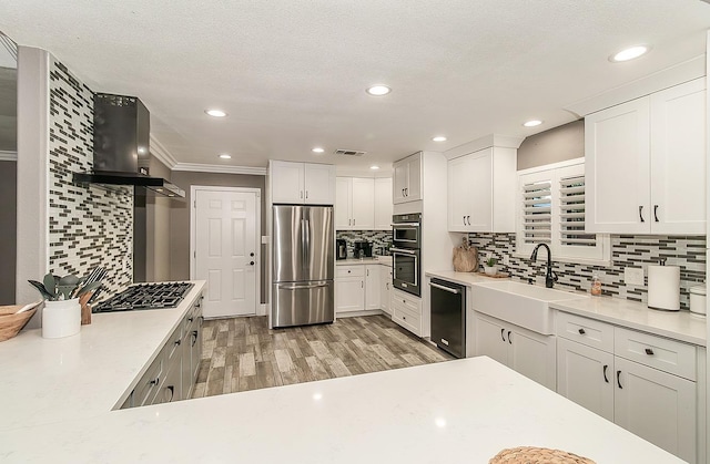 kitchen featuring white cabinetry, sink, wall chimney exhaust hood, black appliances, and light hardwood / wood-style flooring