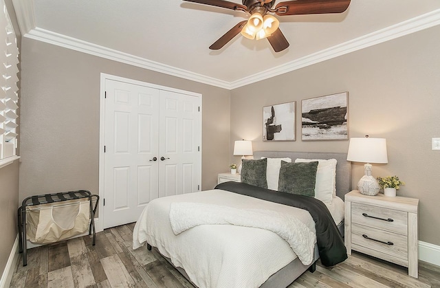 bedroom featuring ornamental molding, hardwood / wood-style floors, ceiling fan, and a closet