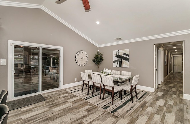 dining area featuring lofted ceiling, wood-type flooring, ornamental molding, and ceiling fan