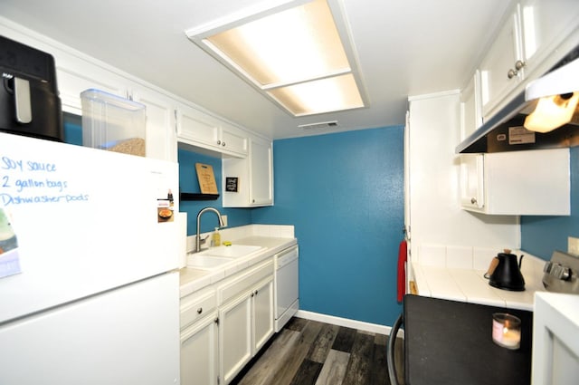 kitchen featuring sink, white appliances, dark wood-type flooring, white cabinetry, and tile counters