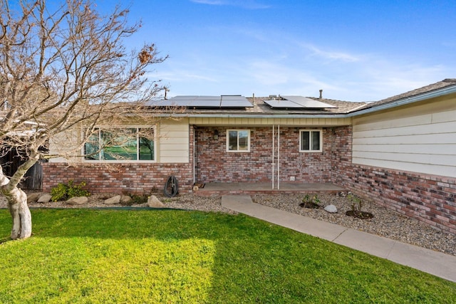 doorway to property with a yard, a patio area, and solar panels