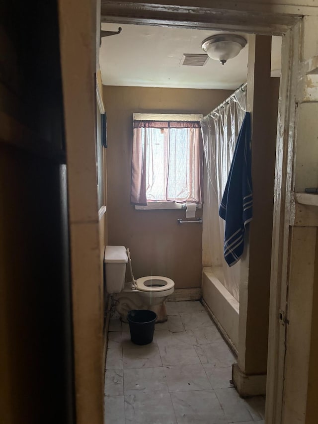 bathroom with toilet and shower / tub combo