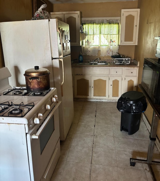 kitchen with sink, light tile patterned floors, and gas range gas stove