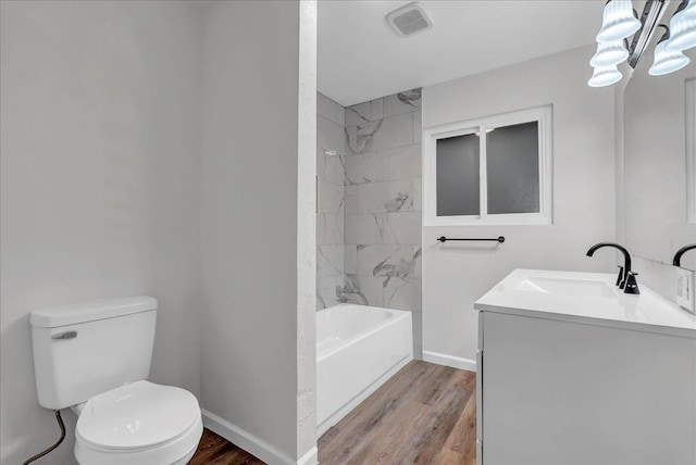 full bathroom featuring tiled shower / bath combo, vanity, wood-type flooring, and toilet