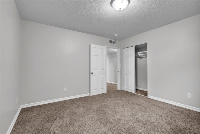 unfurnished bedroom with carpet flooring, a closet, and a textured ceiling