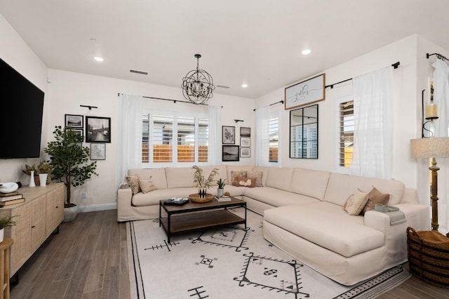 living area featuring recessed lighting, baseboards, an inviting chandelier, and dark wood-type flooring