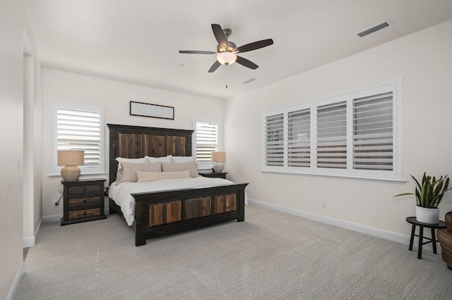 carpeted bedroom featuring visible vents, baseboards, and ceiling fan