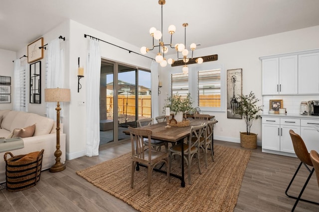 dining area with baseboards, a chandelier, and dark wood-type flooring