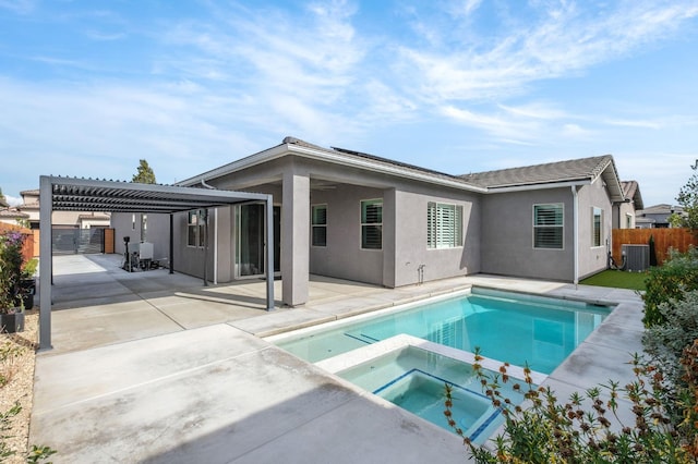 back of property with an in ground hot tub, a pergola, central AC, and a patio area