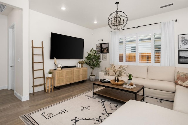 living room with wood finished floors, visible vents, recessed lighting, and a notable chandelier