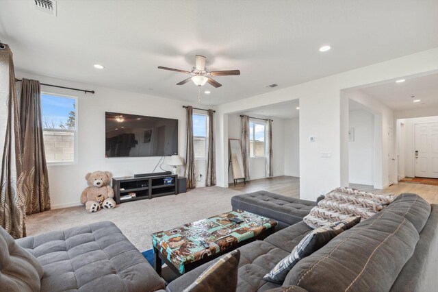 living room featuring light colored carpet and ceiling fan