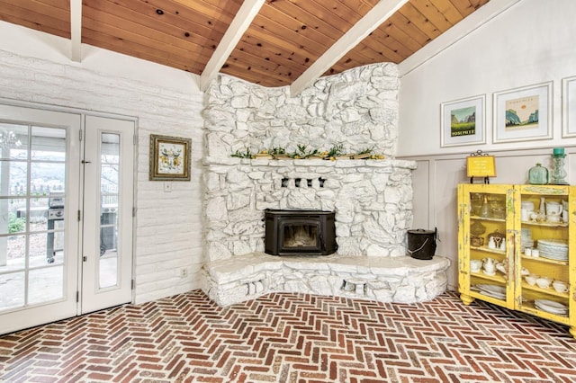 living area with lofted ceiling with beams, wood ceiling, and brick floor