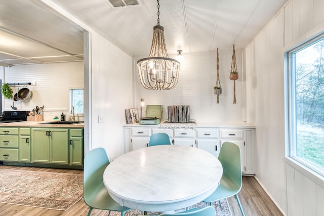 dining area featuring a chandelier, visible vents, and light wood-type flooring