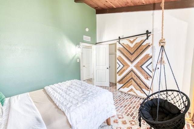 bedroom featuring a barn door, beam ceiling, brick floor, wooden ceiling, and visible vents