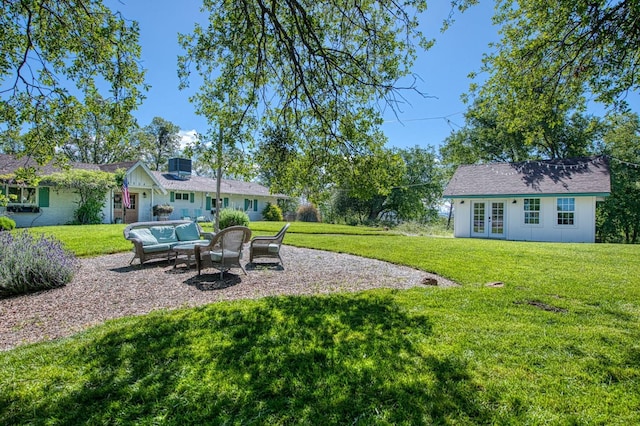 view of yard featuring a patio, an outdoor living space, french doors, and an outdoor structure