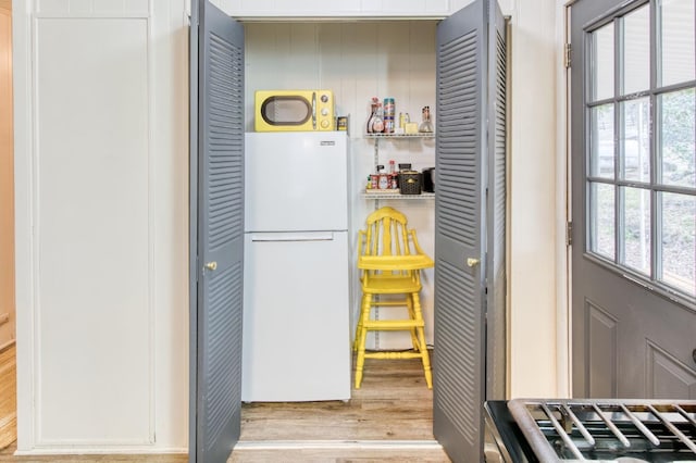 kitchen with freestanding refrigerator, light wood-style flooring, and white cabinets