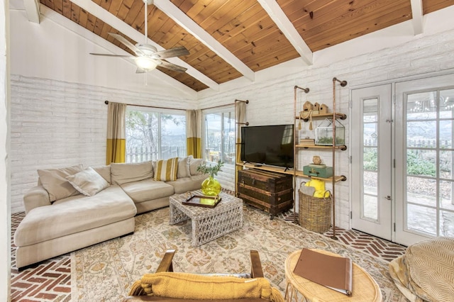 living area with a ceiling fan, lofted ceiling with beams, wood ceiling, and brick floor