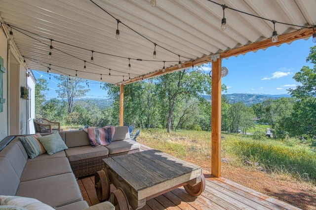 wooden terrace with a mountain view and an outdoor hangout area