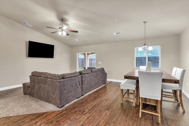 living room with lofted ceiling, dark hardwood / wood-style flooring, and a wealth of natural light