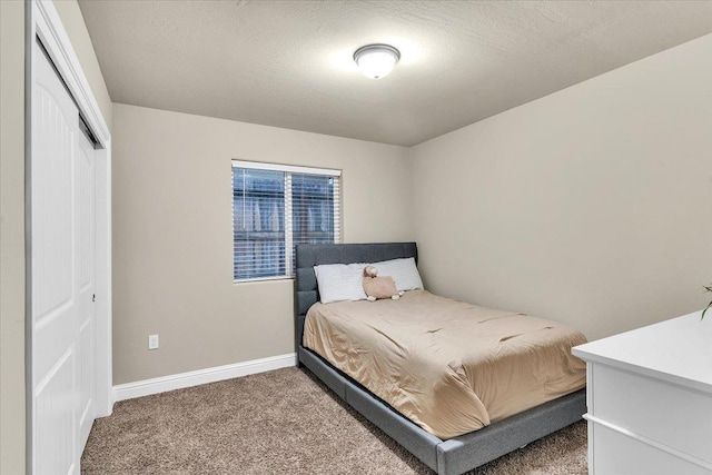 carpeted bedroom with a closet and a textured ceiling