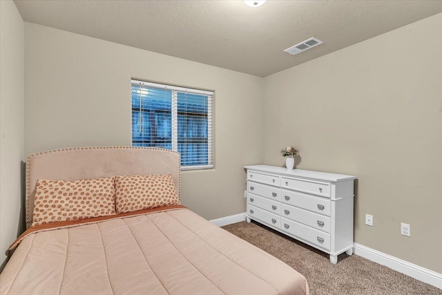 bedroom with carpet and a textured ceiling