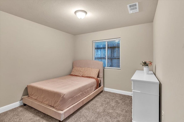 bedroom featuring carpet flooring and a textured ceiling