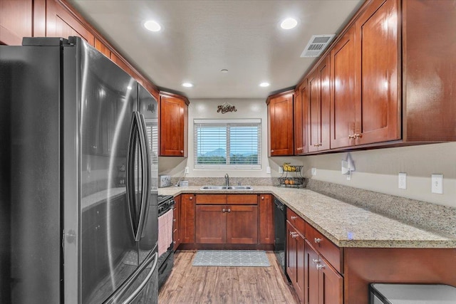 kitchen with sink, fridge, dishwasher, light stone countertops, and stove