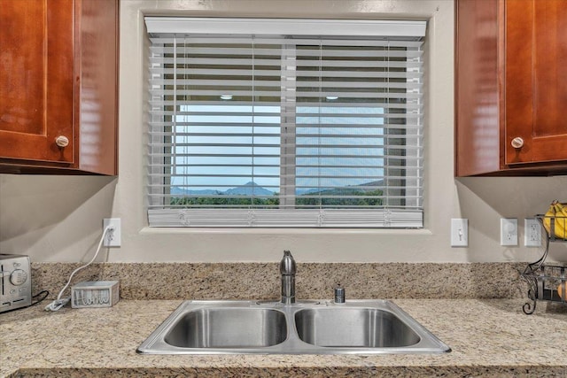 kitchen featuring light stone countertops and sink