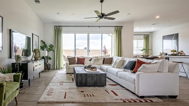 living room featuring ceiling fan and light hardwood / wood-style flooring