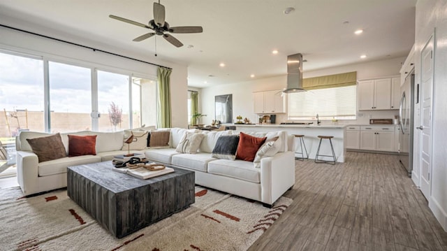 living area featuring recessed lighting, a ceiling fan, and wood finished floors