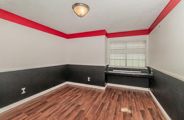 unfurnished room with dark hardwood / wood-style flooring and a textured ceiling