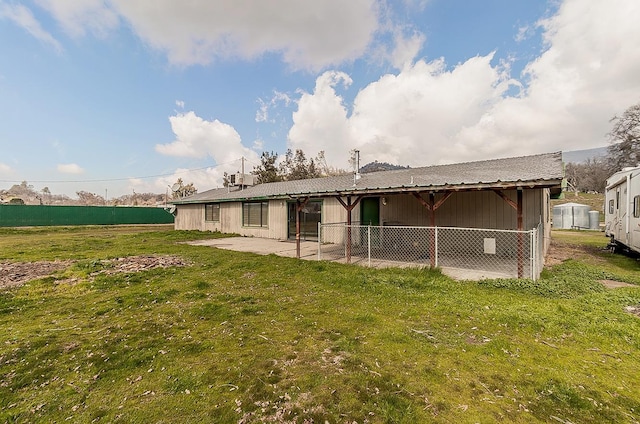 rear view of house with a patio and a yard