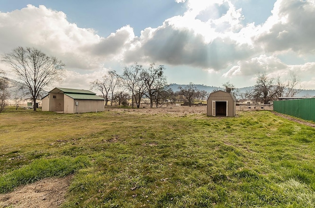 view of yard with a storage shed and a rural view