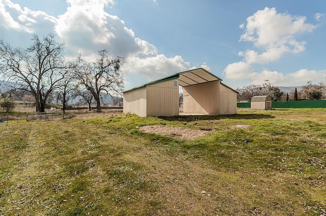 view of outbuilding with a rural view and a yard