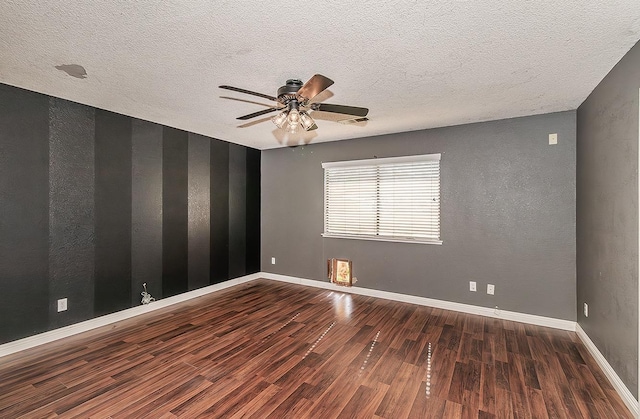 empty room with dark hardwood / wood-style flooring, ceiling fan, and a textured ceiling