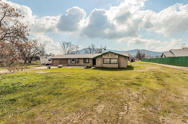 back of house with a mountain view and a yard