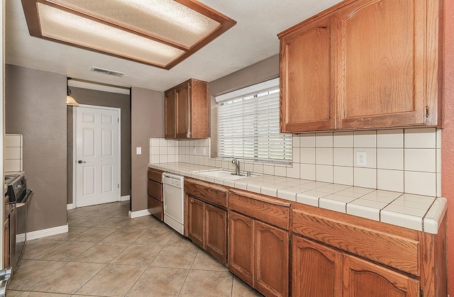 kitchen with tile countertops, dishwasher, sink, decorative backsplash, and light tile patterned floors