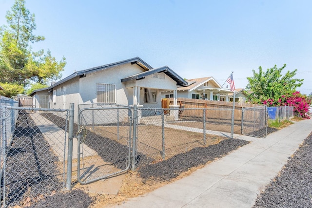 view of front of home with a fenced front yard, a gate, and stucco siding